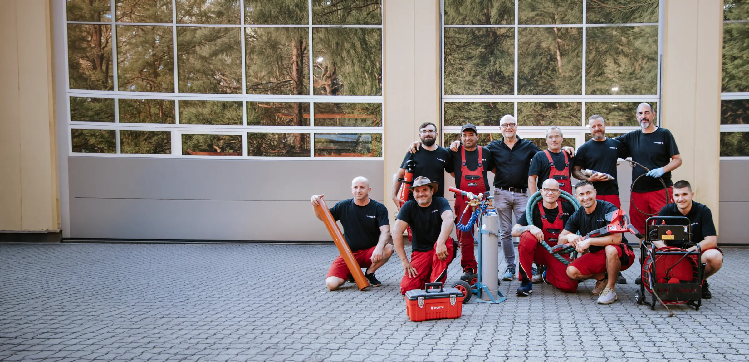 Team der Baier Rohrreinigung GmbH mit Ausrüstung vor der Halle in Erlangen