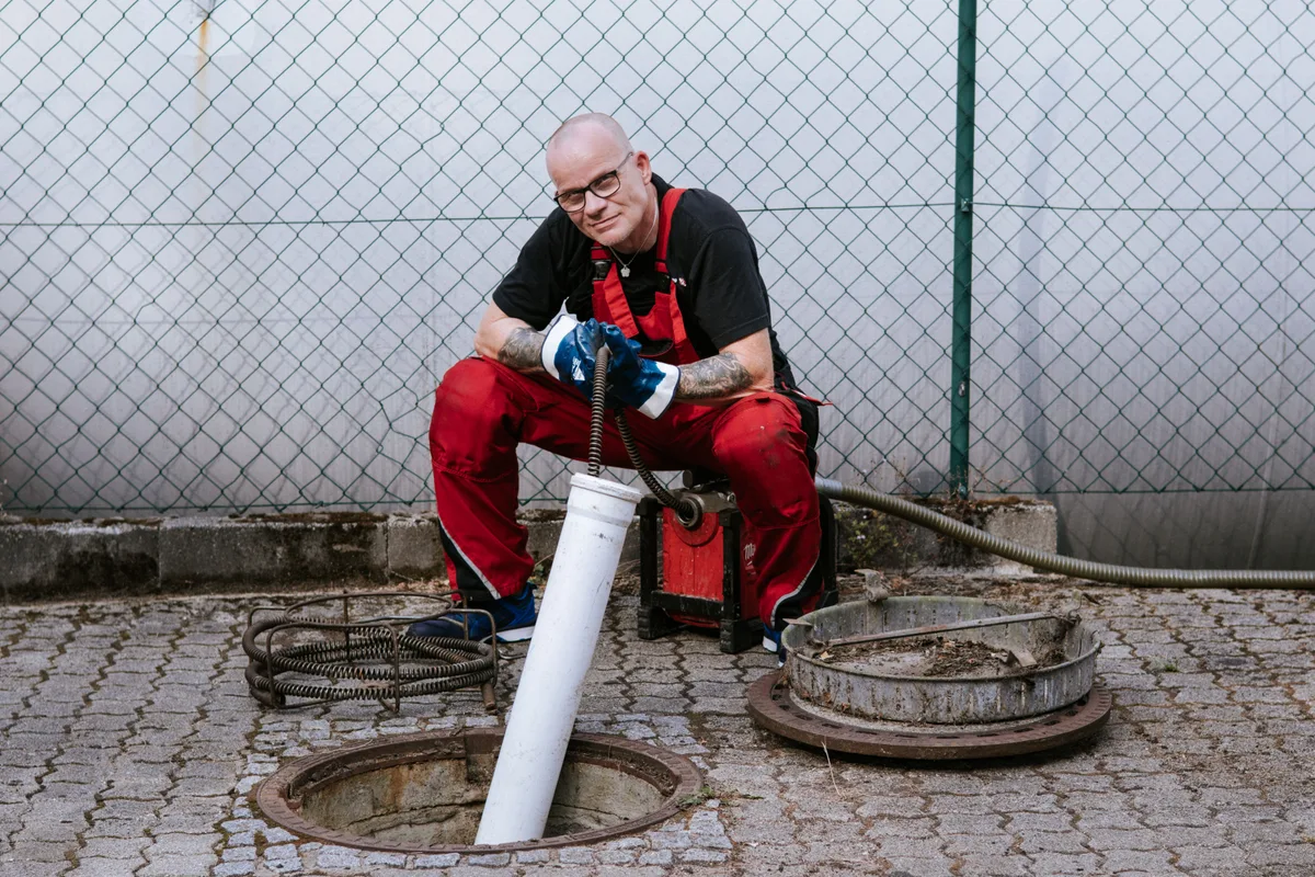 Techniker der Baier Rohrreinigung am offenen Kanalschacht